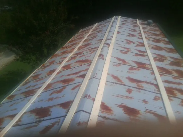 Rusted metal roof panels with new wood purlins before replacement — Storm Damage Roof Repair in Hanley Falls by Roofing Brothers